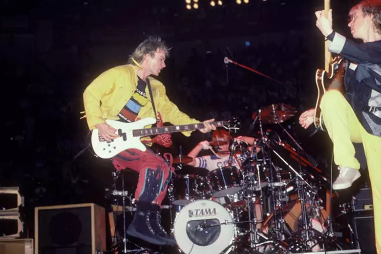 Sting, Stewart Copeland, and Andy Summers performing live on stage, creating The Police's music during a concert performance.
